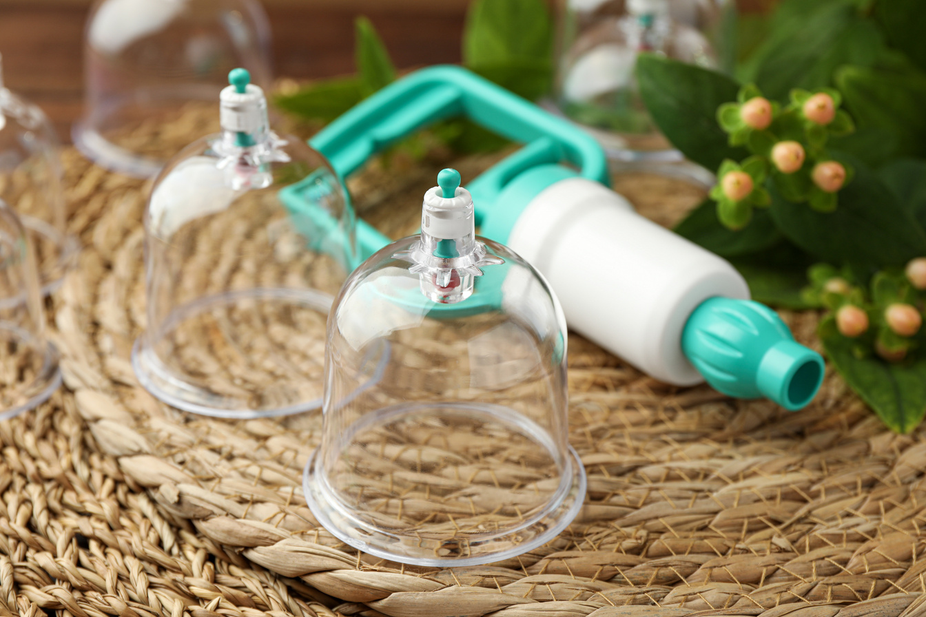 Cupping . Plastic Cups and Hand Pump on Wicker Mat, Close